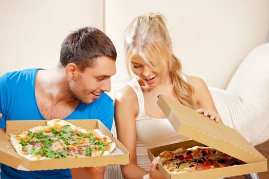 picture of happy romantic couple eating pizza at home (focus on man)