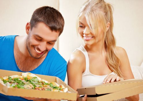 picture of happy romantic couple eating pizza at home (focus on woman)