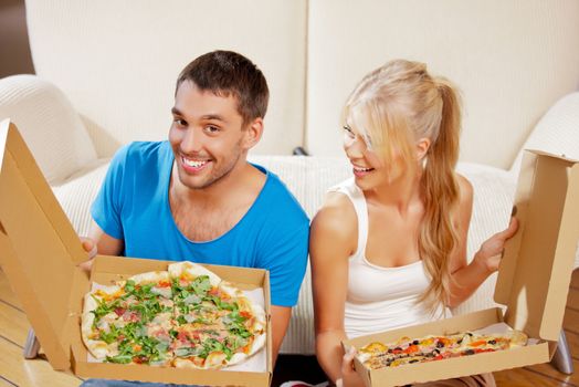 picture of happy romantic couple eating pizza at home (focus on man)