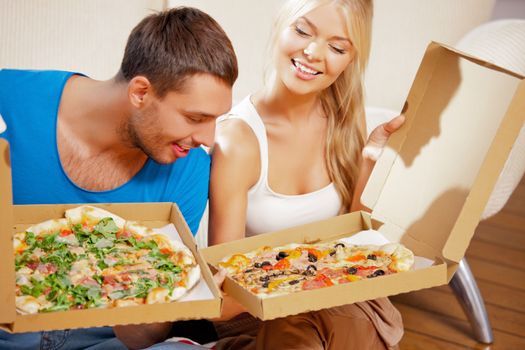 picture of happy romantic couple eating pizza at home (focus on man)