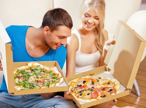 picture of happy romantic couple eating pizza at home (focus on man)