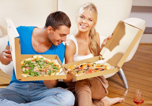 picture of happy romantic couple eating pizza at home (focus on man)