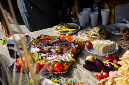 large tray full of smoked meat vegetable fat sausage slices on the regale table