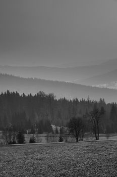 Black and white landscape of hills, mountains and valley in the fog