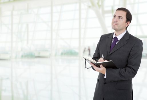 young businessman writing in a book at the office