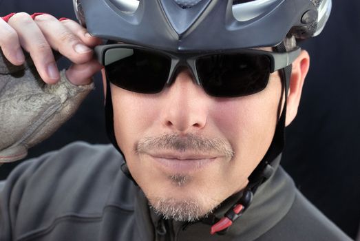 Close-up of a friendly bicycle courier putting on his sunglasses.