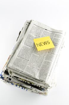 stack of newspaper with post it write news word