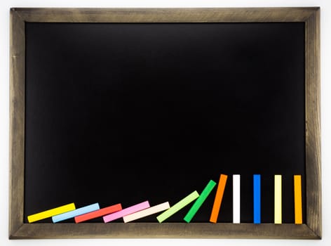 blank  blackboard with domino colorful chalks and wooden frame , back to school and announcement concept and ideas.