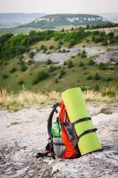 packed backpack at the peak of mountain