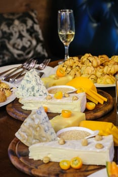 banquet table, various cheeses on wooden plate, profiteroles