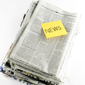stack of newspaper with post it write news word