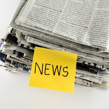 stack of newspaper with post it write news word