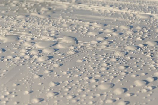 rain water drops glisten on white material surface background.