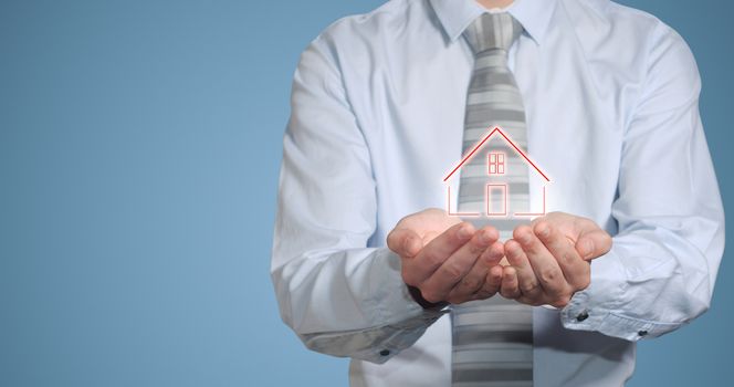 Businessman or banker man holding home or house in hands