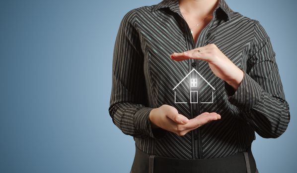 Businesswoman or banker woman holding home or house in hands