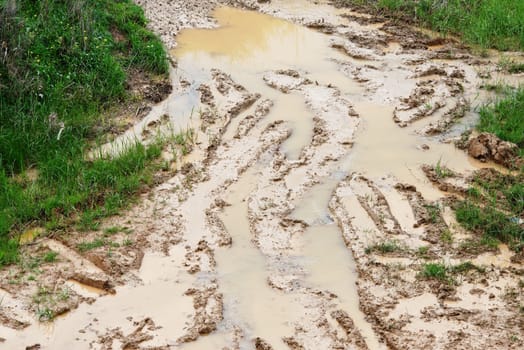 Car ruts in dirty road mud 