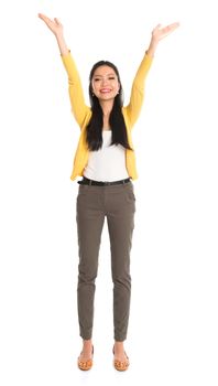 Asian girl arms up like holding something above, full length standing isolated on white background.