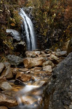 Beautiful waterfall and stream flowing over wet rocks