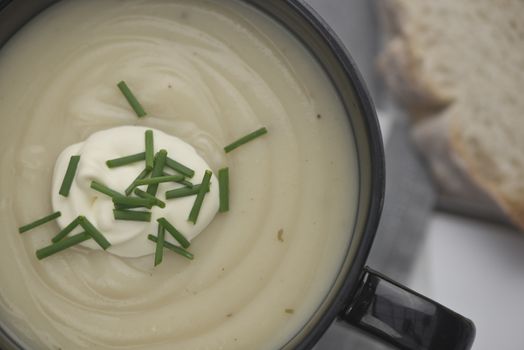 Mug full of fresh homemade potato soup garnished with cream and chives