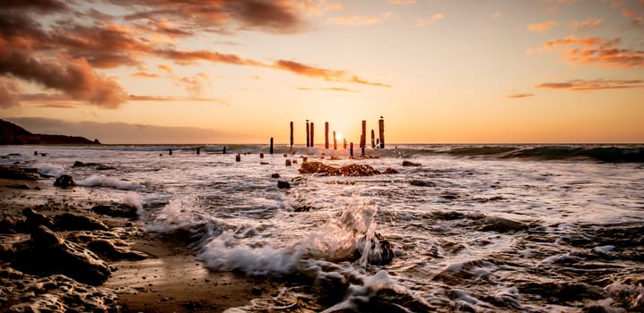 Coastal sunset over the remains of an old jetty