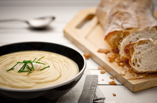 Mug full of fresh homemade potato soup garnished with cream and chives