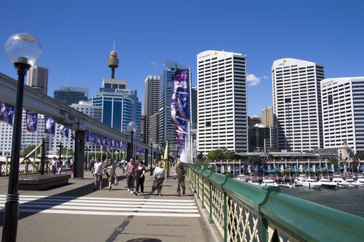 Sydney, Australia-March 17th 2013: Pedestrians crossing the bridge at Darling Harbour. The harbour is named after Ralph Daring who was Governor of NSW from 1825 to 1831.
