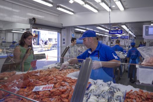 Sydney, Australia-March 17th 2013: A customer buys prawns at Sydney Fish Market. Established in 1945, the market is the world's thied largest.