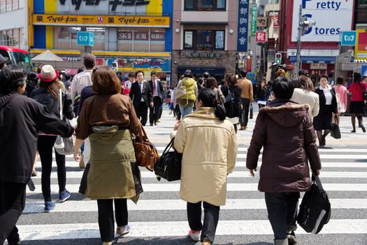 Tokyo, Japan - April 15, 2014 Crowds of pedestrians crossing the busy downtown streets of Shibuya, the most important commercial center in Tokyo, Japan