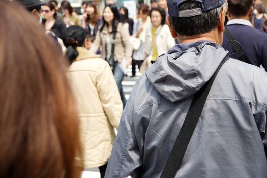 Tokyo, Japan - April 15, 2014 Crowds of pedestrians crossing the busy downtown streets of Shibuya, the most important commercial center in Tokyo, Japan