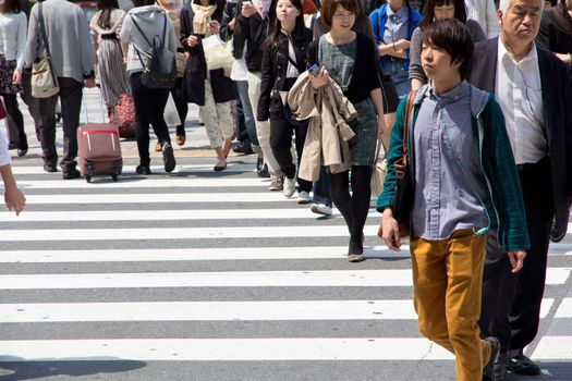 Tokyo, Japan - April 15, 2014 Crowds of pedestrians crossing the busy downtown streets of Shibuya, the most important commercial center in Tokyo, Japan