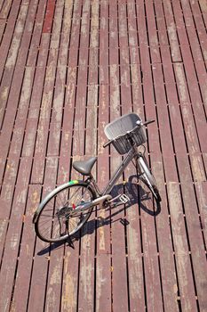 The bicycle on wooden background