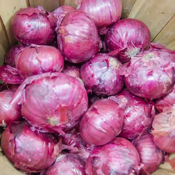 red onions in basket on display on market farm