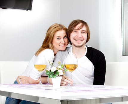 young woman in home having meal and wine with her husband