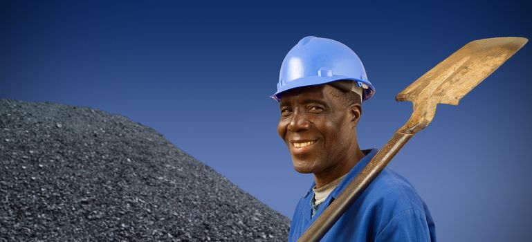 South African or African American coal miner with coal pile
