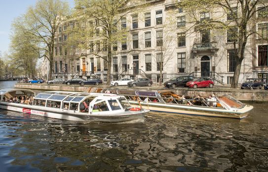 Amsterdam, The Netherlands - April 05, 2014; An Amsterdam Canal Cruise is most popular tourist attraction . A diverse fleet of around 200 tour boats carry more than 3 million passengers a year.