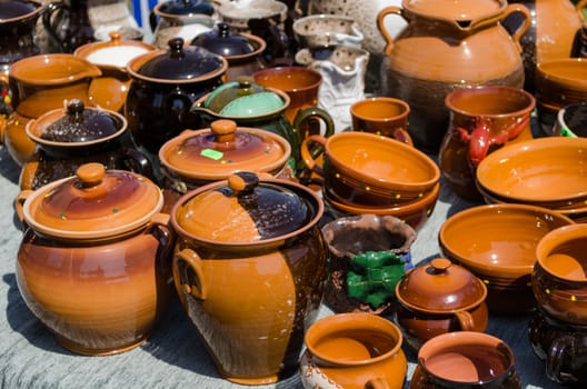 handmade clay pots and cups of various sizes and shapes on fair stall