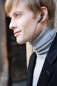 attractive man in urban background listening to the music 