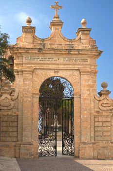 Gate in the wall leads to a little pedestrian plaza beside the Sanctuary of Our Lady of Mellieha - Mellieha, Malta.