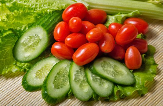 Still life close-up of lettuce, tomatoes, cucumber and celery