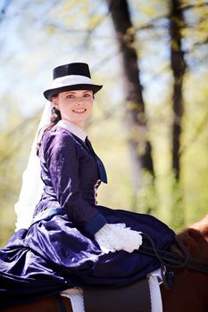 Lady on a  horse. The lady on riding walk. Portrait of the horsewoman. The woman astride a horse. The aristocrat on riding walk.