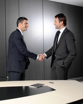 Serious businessmen shaking their hands after a meeting at the office