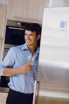Man with his wineglass in his kitchen at home 