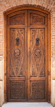 Decorated old wooden door with metal handles