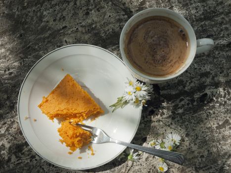 Pumpkin cheese cake in plate on the stone table with cup of coffee