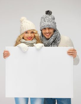 picture of family couple in a winter clothes holding blank board