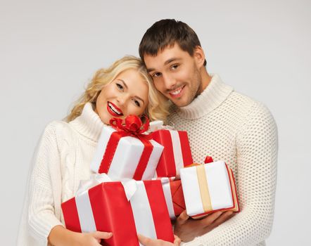 picture of romantic couple in a sweaters with gift boxes