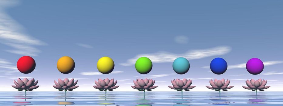 Colorful spheres for chakras upon beautiful pink lily flowers by day light
