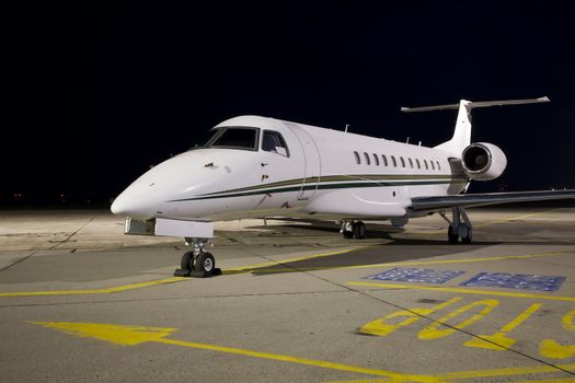 Small jet plane parked at night