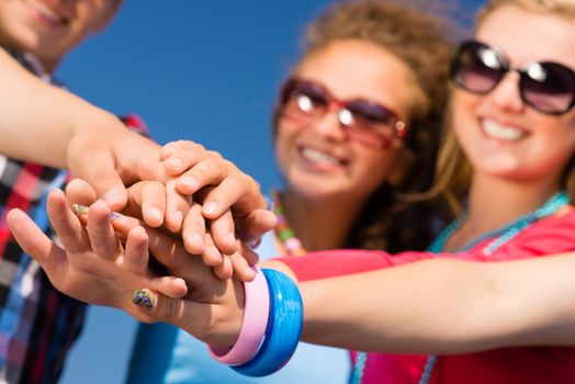 group of friends with arms folded in a column, teamwork