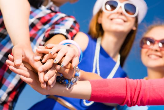 group of friends with arms folded in a column, teamwork